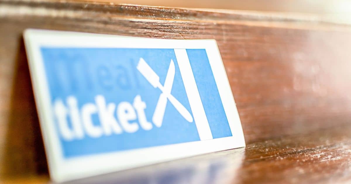 Ticket Restaurant? Een plaatje met daarop het woord 'ticket' en gekruiste mes en vork ligt op een houten kast of plank?