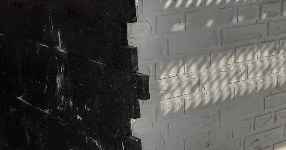 Witte crepi met baksteenpatroon aangebracht op een muur met behulp van mallen