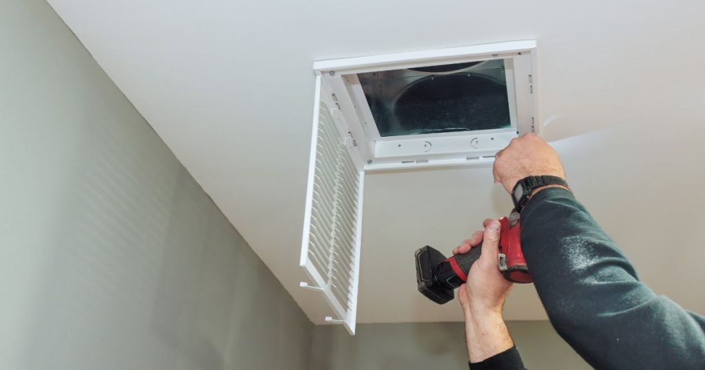 Een professionele ventilatie installateur voert onderhoud en reiniging uit aan een mechanisch ventilatiesysteem voor een optimaal binnenklimaat.