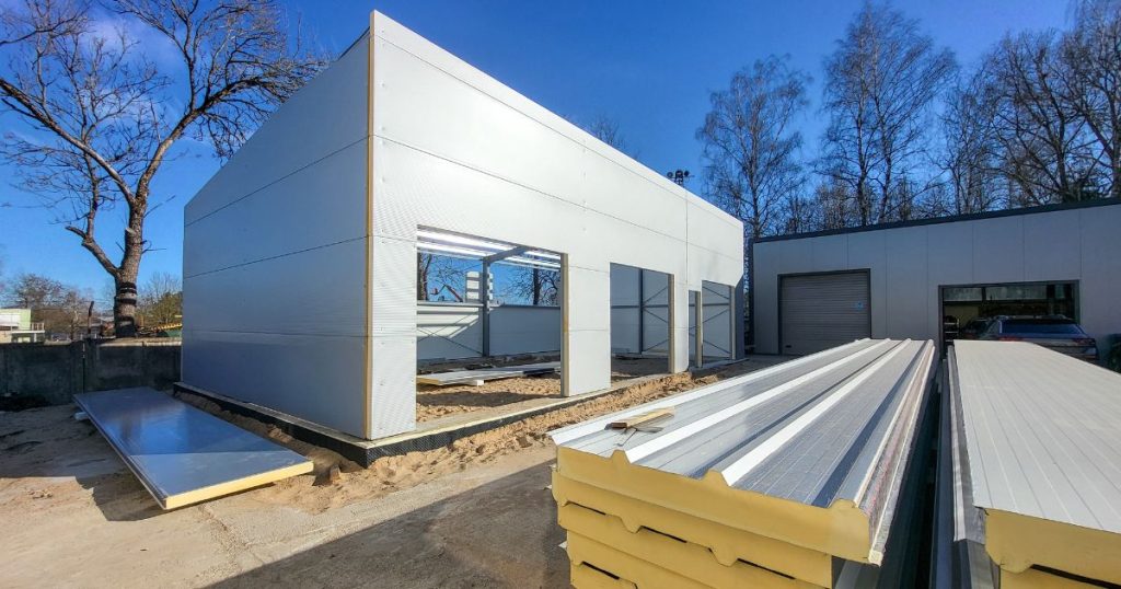 Montage van sandwichpanelen aan de gevel van een industrieel gebouw