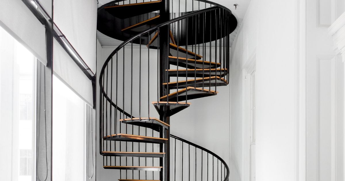 Zwarte spiltrap met houten treden.