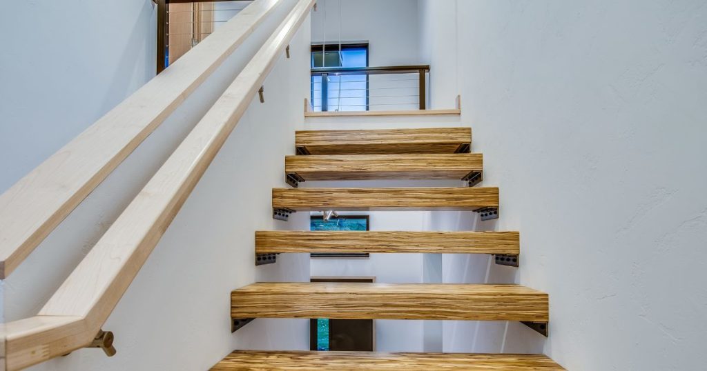 Vooraanzicht van een open trap die tijdens een traprenovatie bekleed werd met HPL overzettreden in houtlook