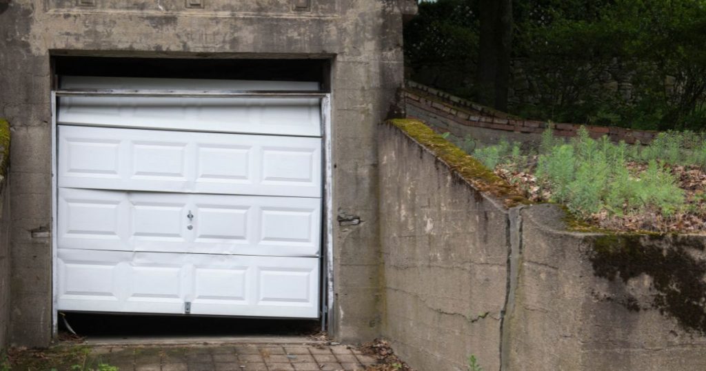 Beschadigde, verwaarloosde garagepoort