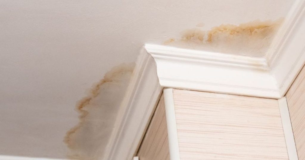 Bruine vochtplekken op plafond door een lekkende leiding
