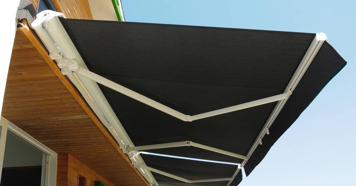 Zwarte buiten zonwering met een elektrische bediening boven een terras. 