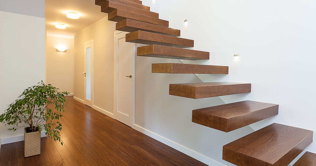 Een zwevende trap met houten treden aan een witte muur.