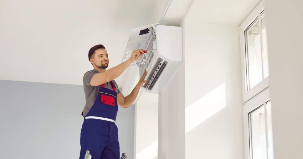 Een airco installateur repareert een airco