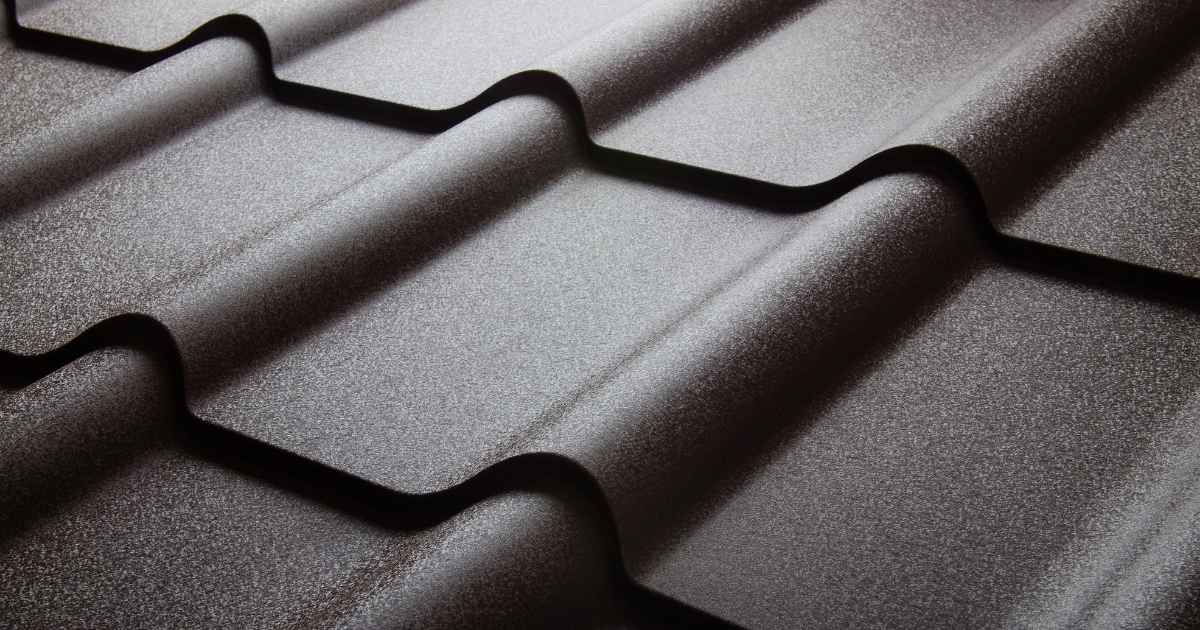Close-up van geïsoleerde dakpanplaten: een dakpaneel voorzien van een dakpanprofiel. De plaat heeft een grijsbruine kleur.