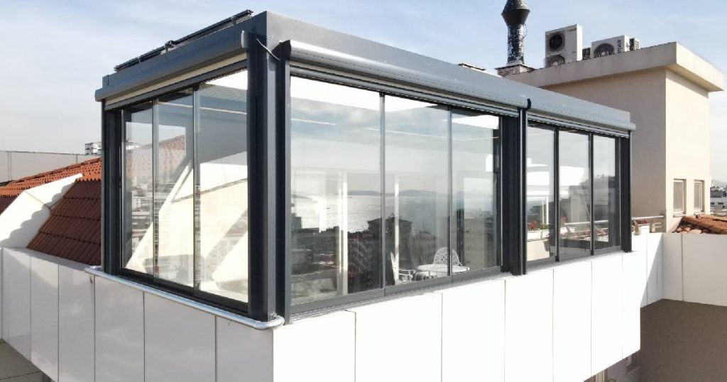 Een moderne aluminium veranda op een dakterras met zwarte, elegante profielen.