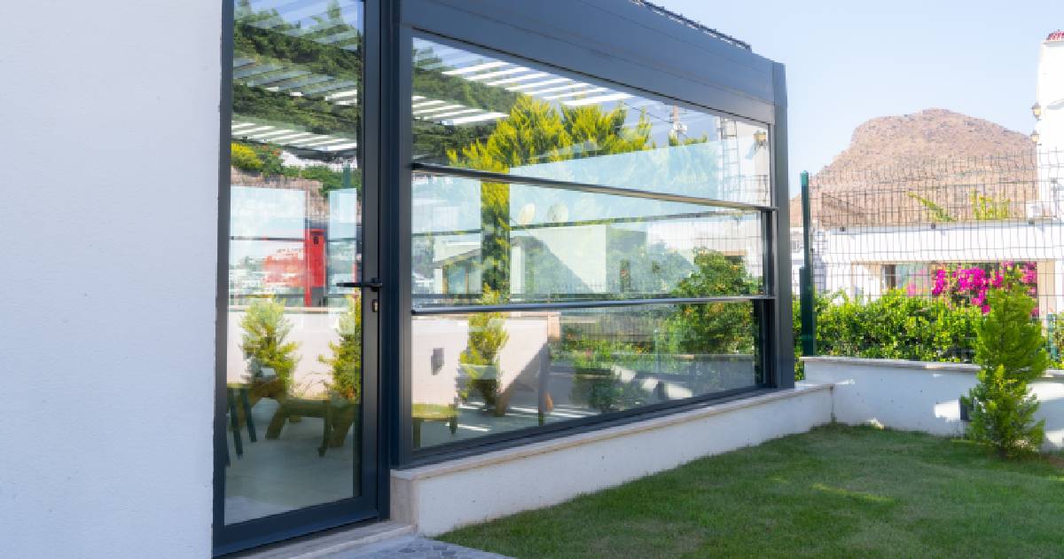 Een moderne aluminium veranda met slanke, zwarte profielen en grote ramen.