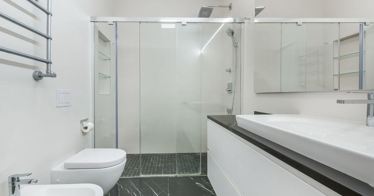 Badkamer met ruime inloopdouche en glazen schuifwand naast wastafel en toilet, voorbeeld van inloopdouche prijs inclusief plaatsing