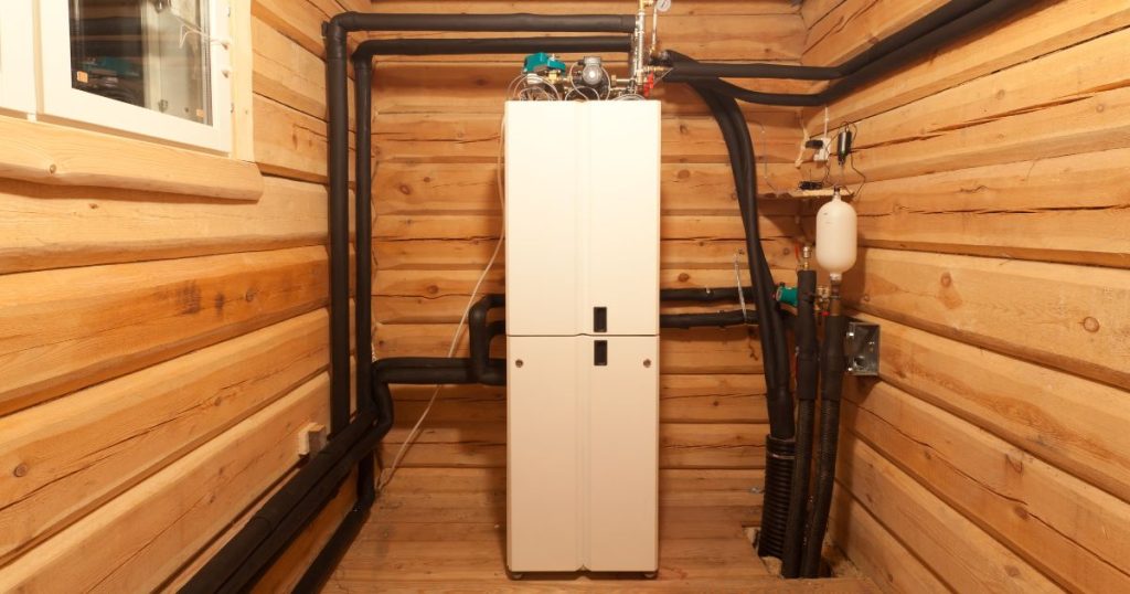 Een geothermische warmtepomp in een kleine technische ruimte met houten wanden en vloer.