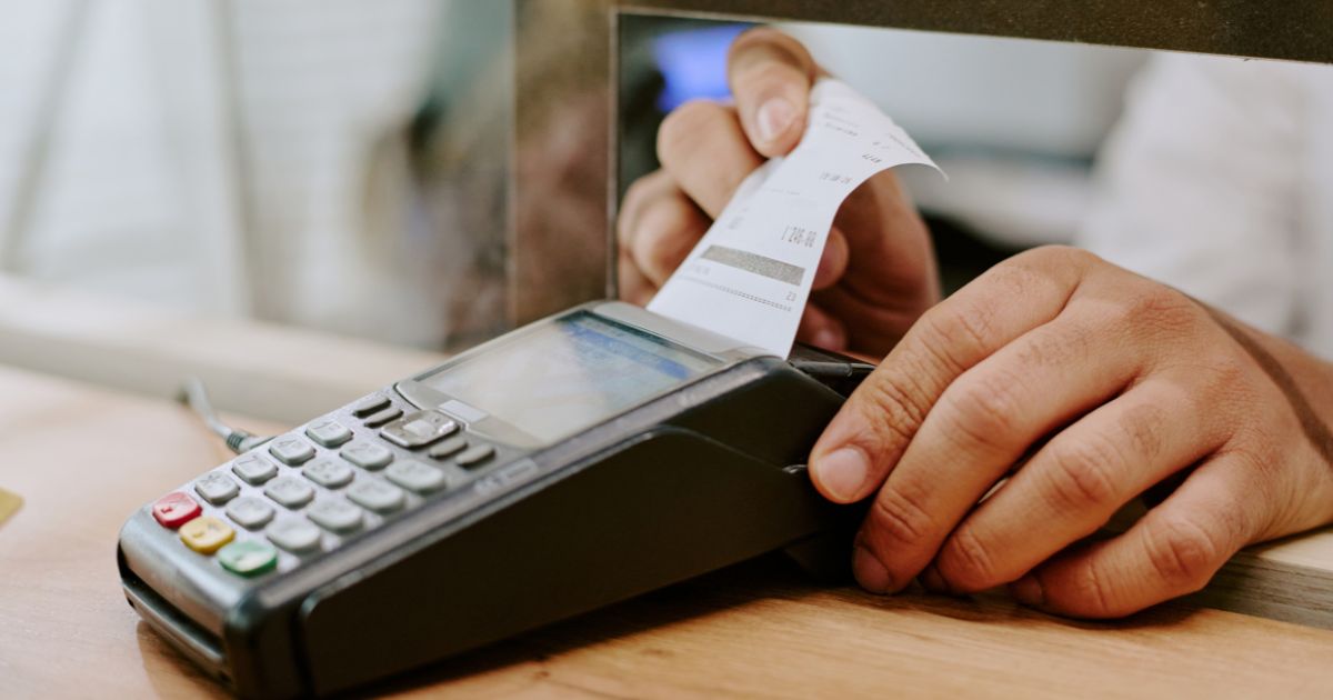 Een ondernemer haalt een betalingsbewijs uit een betaalterminal na een elektronische betaling