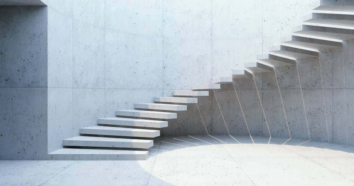 Een ronde, zwevende betonnen trap met gepolijste afwerking.