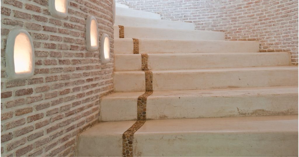 Een ruwe betonnen trap die tussen twee bakstenen wanden is gegoten. 