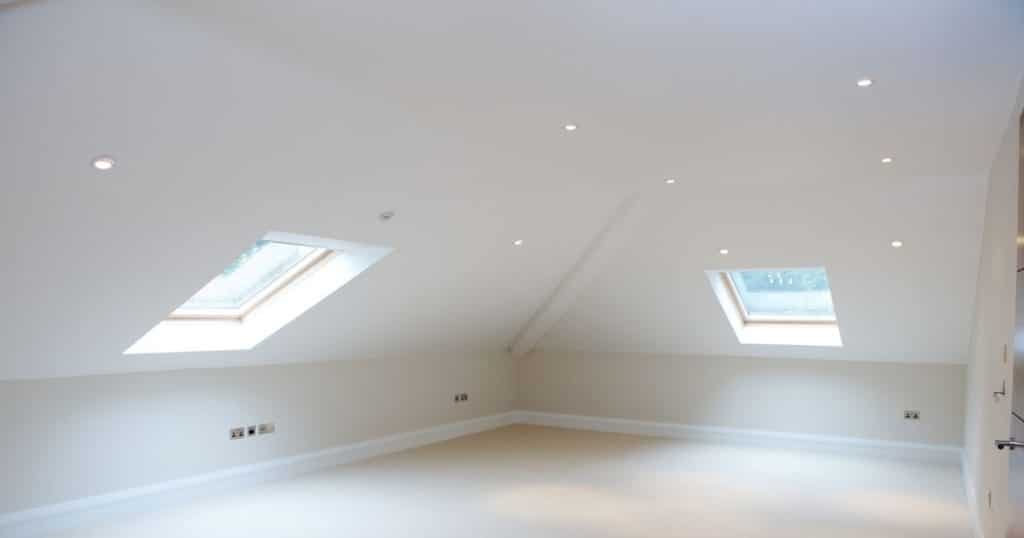 Binnenkant van een zolder onder een schilddak. De witte ruimte is nog niet ingericht. Kenmerkend zijn de 4 schuin aflopende zijdes. De 2 zichtbare schuine zijdes zijn voorzien van kleine dakramen.