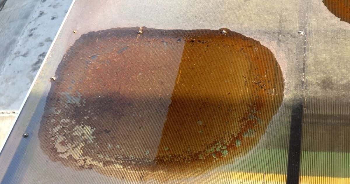 Een bruin-rood-oranje verkleurde vlek op een plat of hellend dak. Mogelijk kan dit op termijn voor problemen zorgen.