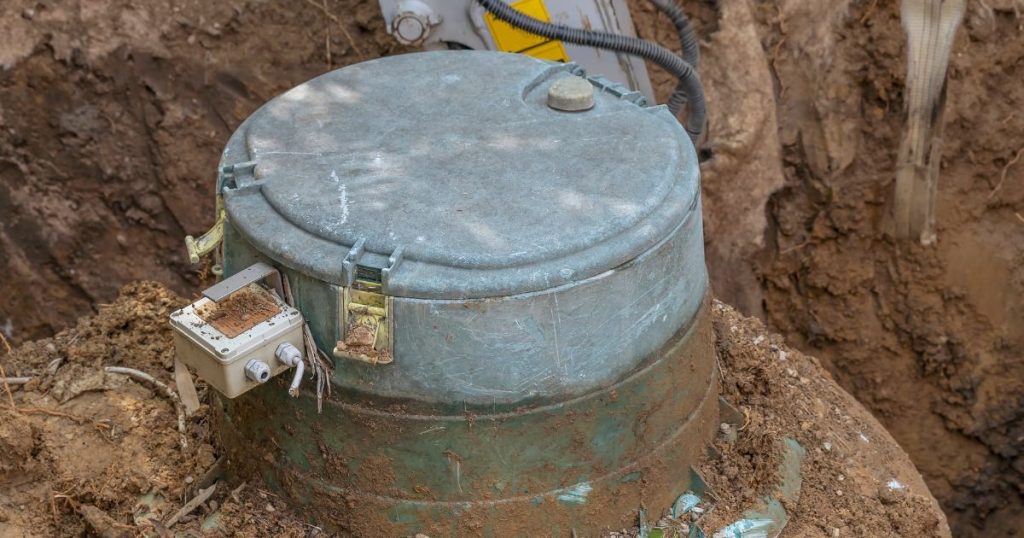 Een oude ondergrondse mazouttank met deksel in een put.