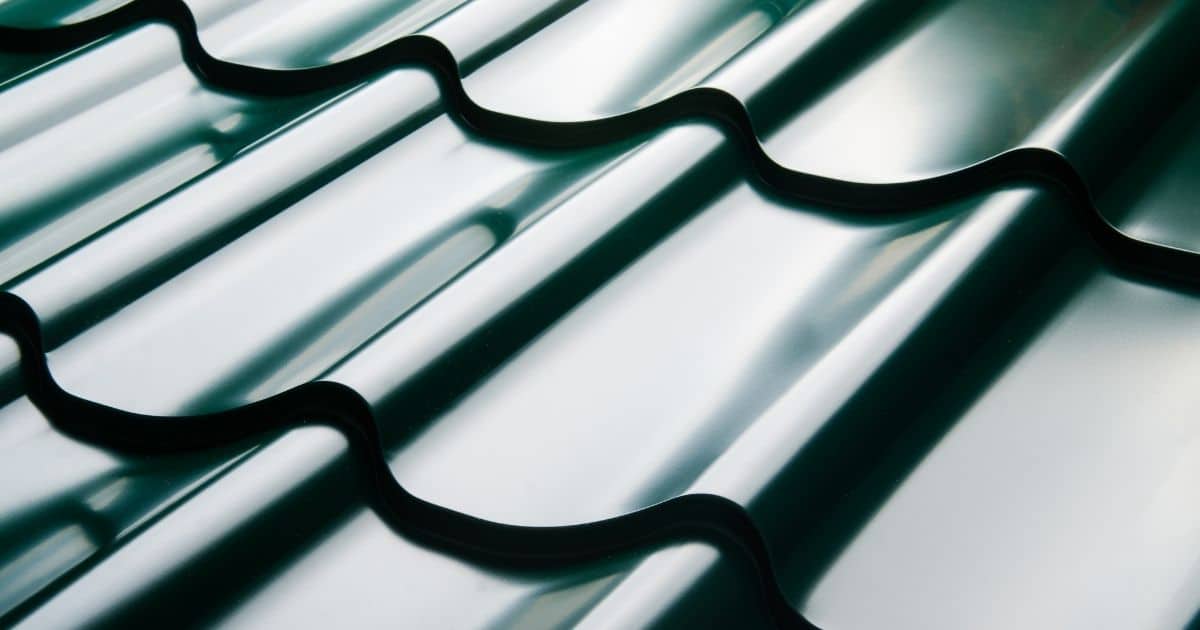 Close-up van grijze, glanzend metalen dakpannen in een dakplaat of sandwichpaneel met dakpanprofiel (ook wel een dakpanplaat genoemd).