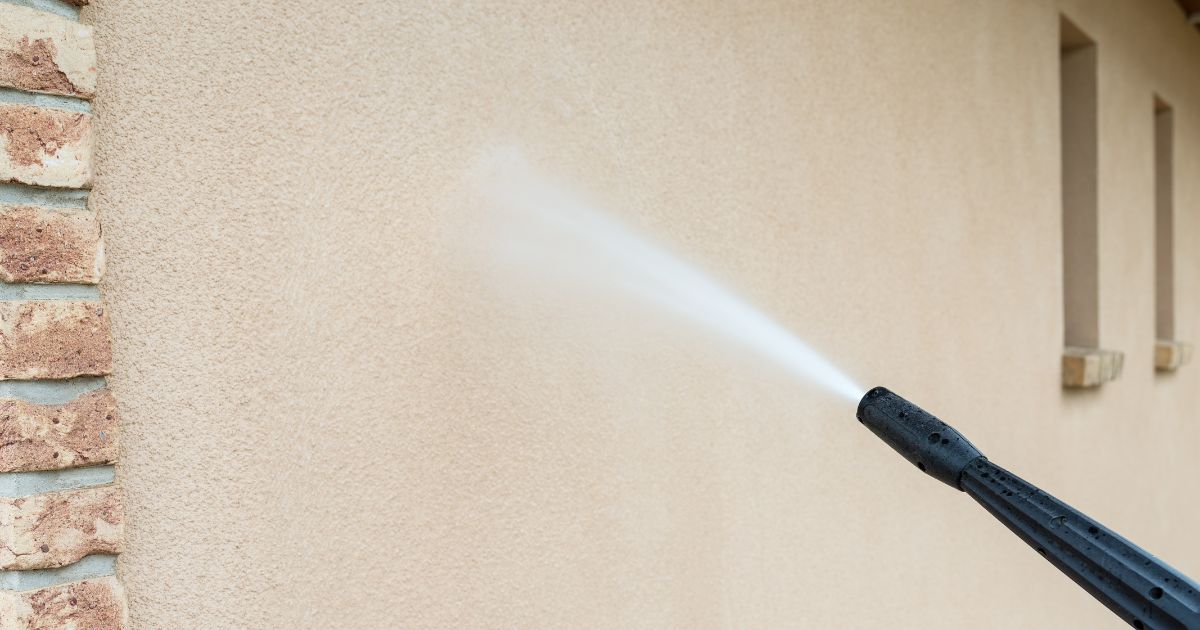 Hogedrukreiniger reinigt gevel van een huis in crepi