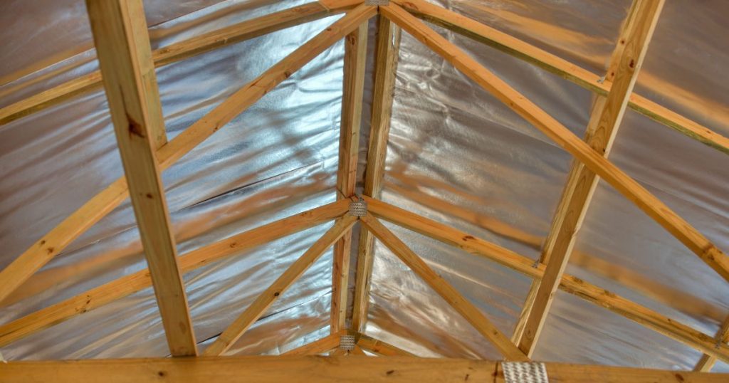 De onderzijde van een spantendak zonder isolatiemateriaal met een duidelijk zichtbaar reflecterend onderdak.