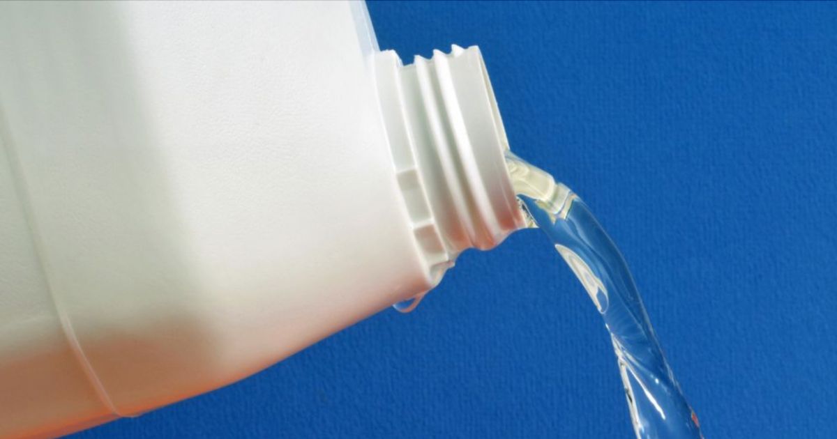 Een witte fles bleek giet bleek ergens op.