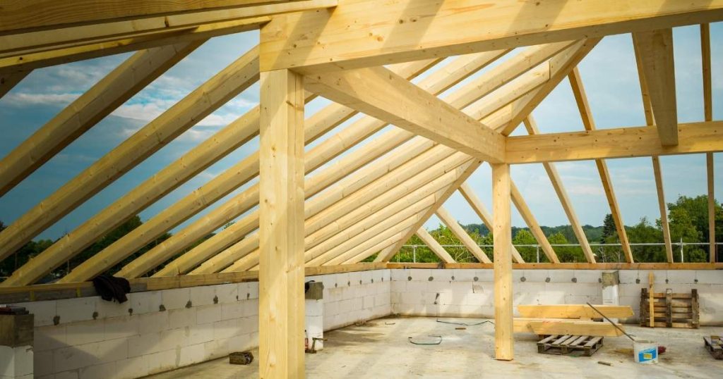 Een houten dakgebinte op een plat, betonnen dak: de basis voor het toevoegen van een extra verdieping met hellend dak.