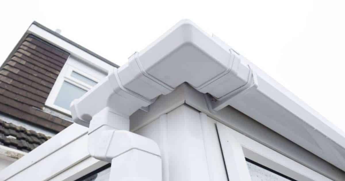 Een witte dakgoot in pvc of aluminium, vermoedelijk aan het uiteinde van een verandadak.
