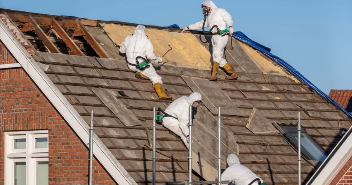 Zowel de platen als de onderliggende isolatie worden verwijderd door gespecialiseerde vakmannen in witte beschermingspakken. Ze dragen ook een masker tegen eventueel vrijkomend asbest tijdens de opruimingswerken.