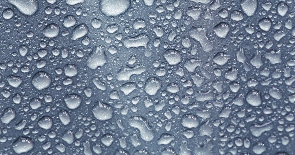 Een raam met condens: vochtige lucht zet zich in kleine druppels af op het koude raamoppervlak. 