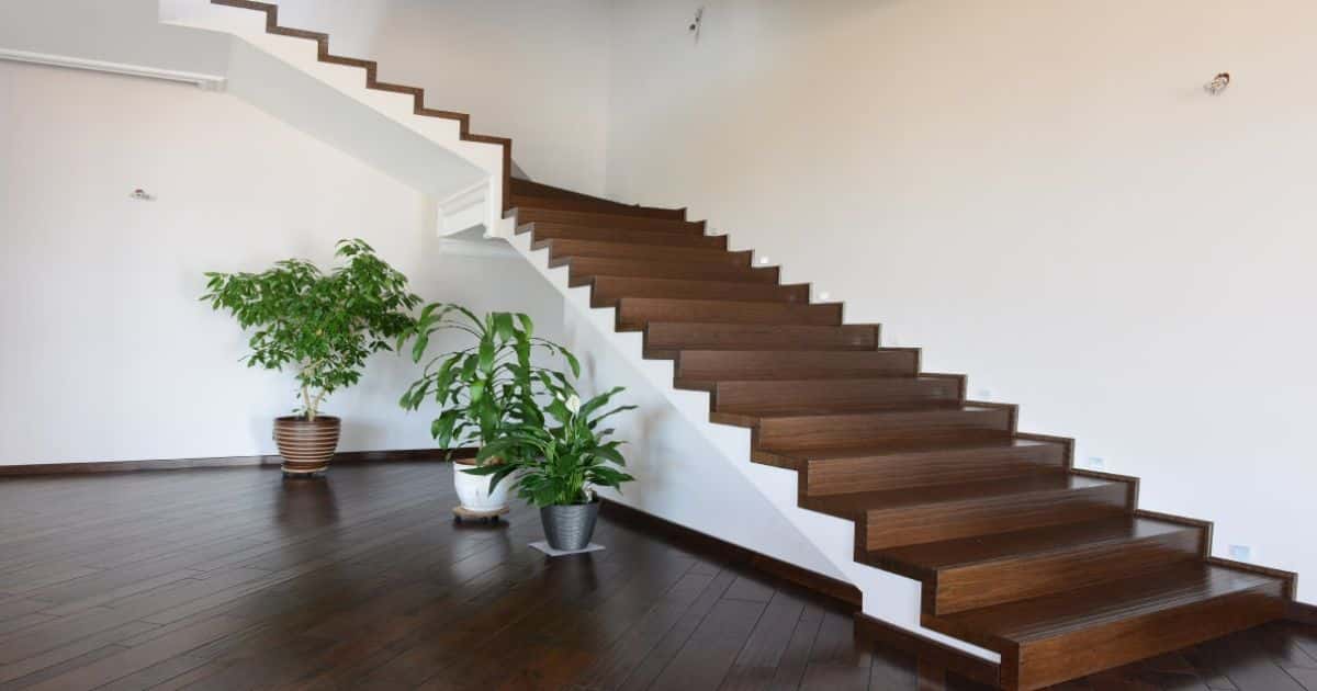 Een donkere trap in houtlook met een kwartdraai naar boven.