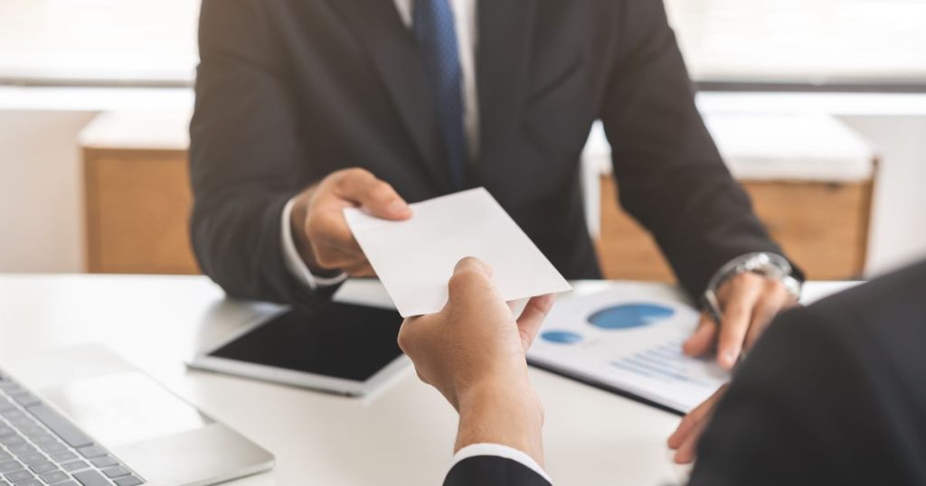 Werkgever geeft een ecocheque aan een werknemer.