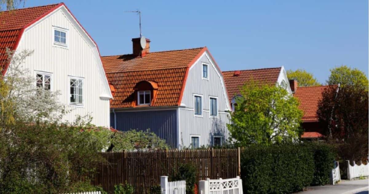 Een straat met twee woningen met monsardedak: een traditionele dakconstructie voor hellende daken met een ouderwetse, gezellige look.