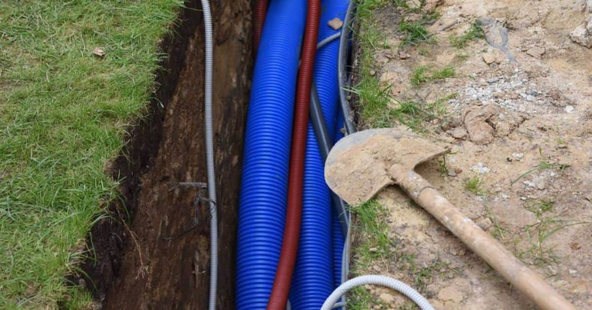 Een gleuf met kabels, gegraven tijdens het installeren van een laadpaal voor thuis.