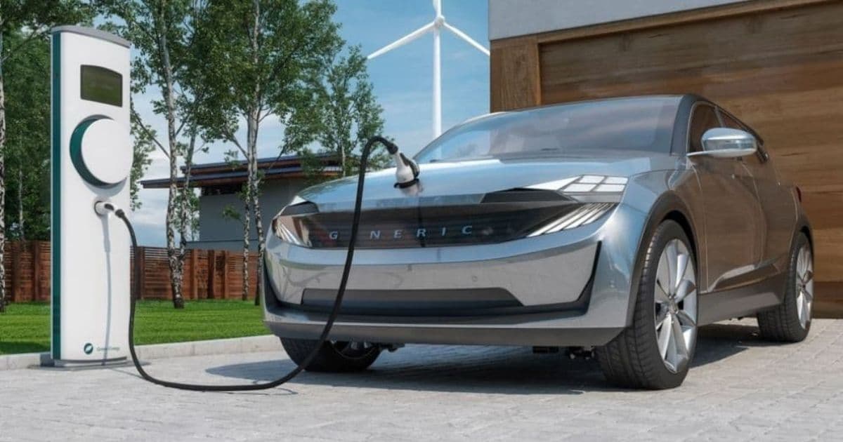 Elektrische auto die thuis op de oprit wordt opgeladen via een laadpaal voor de garage van een woning.