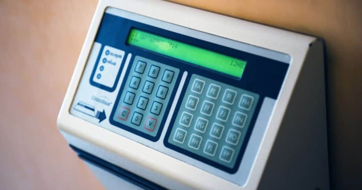 Een wit met blauwe elektronische tikklok of prikklok, met een klein, langwerpig scherm en 2 toetsenborden.