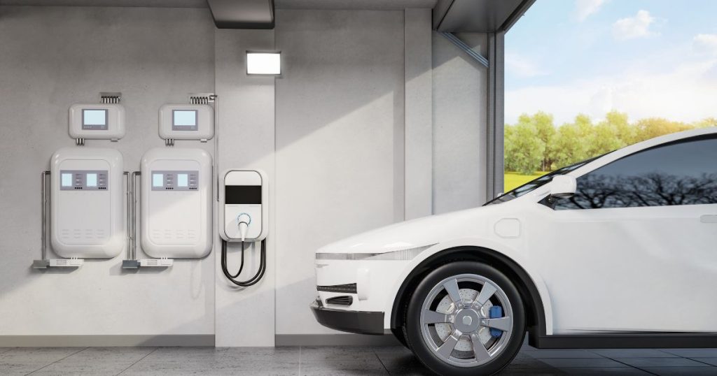 Een garage met een witte wagen, laadpaal in wallbox model en een energieopslagsysteem met thuisbatterij.
