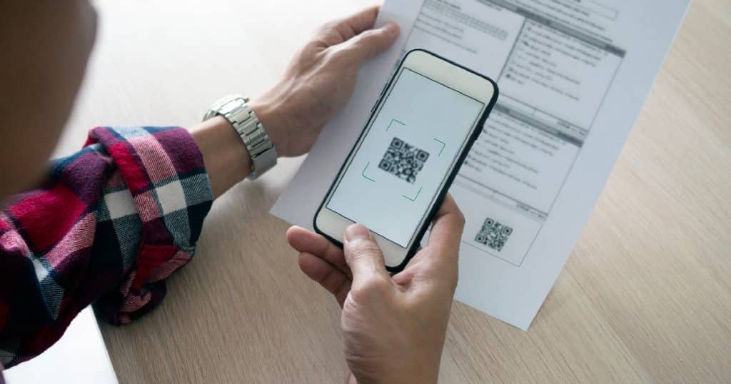Een klant gebruikt een smartphone om een factuur met QR-code te betalen