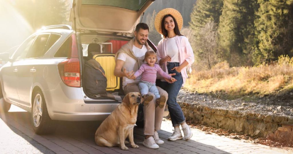 Een familie met vader, moeder, jong dochtertje en een hond, ook op reis met de auto verzekerd door hun familiale verzekering.