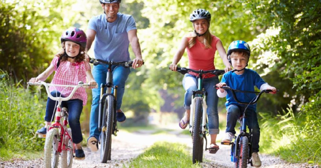 Een gezin met moeder, vader, dochter en zoon op reis met de fiets, gedekt door hun fietsverzekering voor het hele gezin.