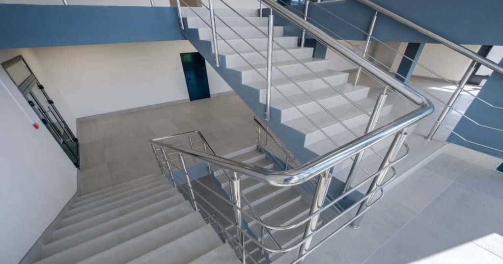 Gietvloer met witte treden en moderne roestvrijstalen leuning