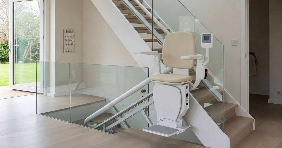 Een moderne hal met open trap met glazen wanden en een traplift voor verschillende verdiepingen.