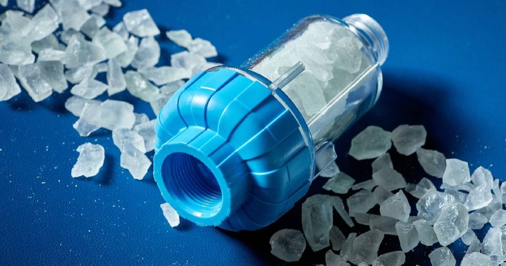 Een capsule met polyfosfaatzout voor een goedkope waterontharder op een blauwe achtergrond.