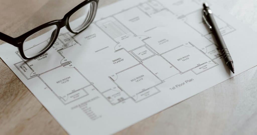 Een eendraadschema van een elektrische installatie waarop een bril en een pen liggen.