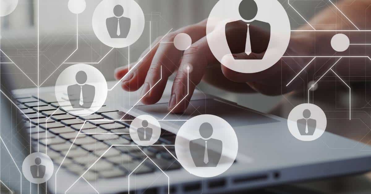 Verschillende witte, deels transparante icoontjes van mannen met das in een witte cirkel. Daarachter een grijze laptop, met een hand boven de mousepad.