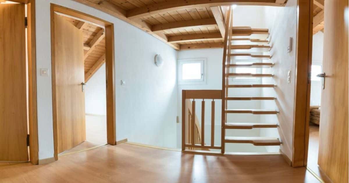 Een lichte, ruimtebesparende middenboomtrap op een verdieping met 3 deuren in dezelfde soort en kleur hout.