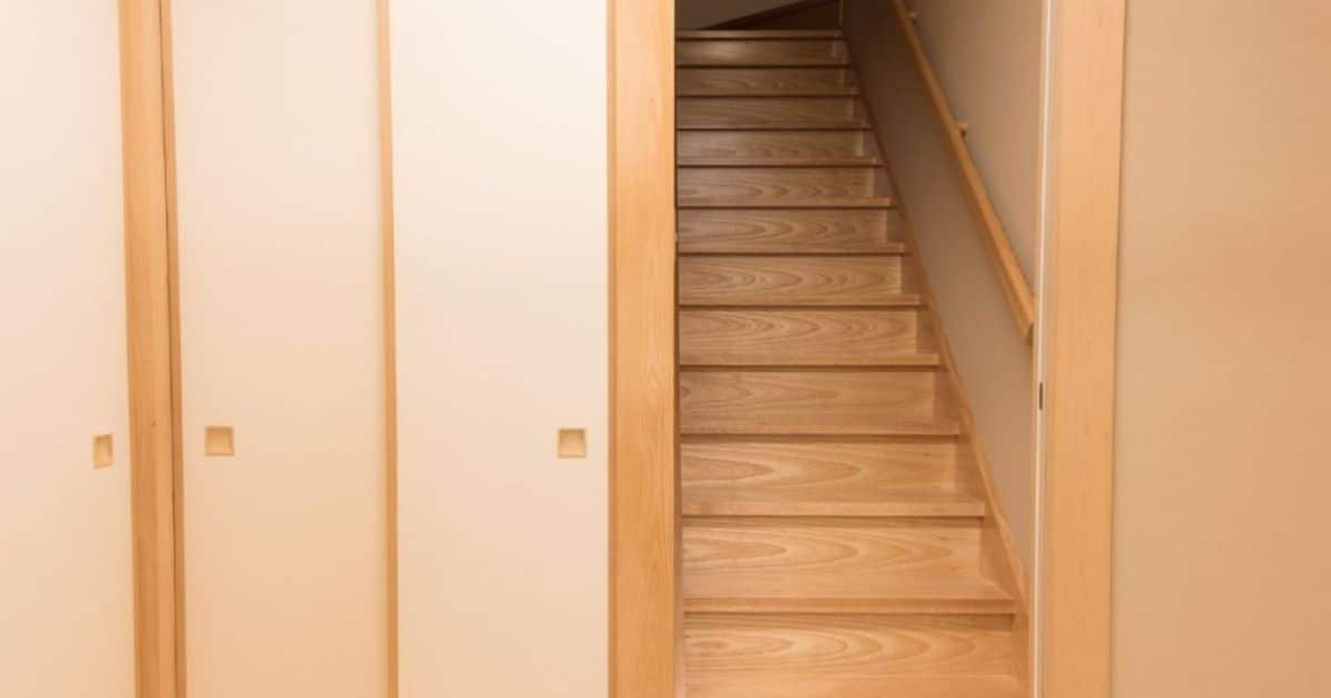 Vooraanzicht van een houten molenaarstrap in een lichte houten kleur.