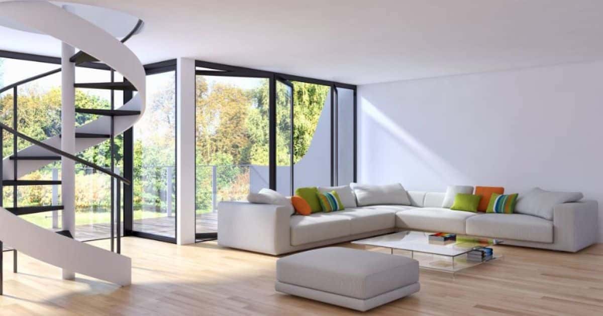 Geverfde open wenteltrap in een moderne woning met een witte zetel en kleurrijke kussens.