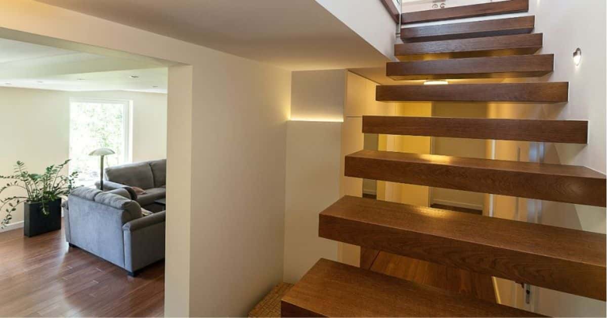 Een zwevende houten trap met trapverlichting die men op maat heeft laten maken.