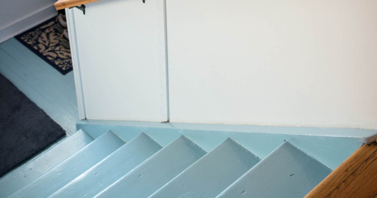 Een houten trap die men lichtblauw heeft laten schilderen.